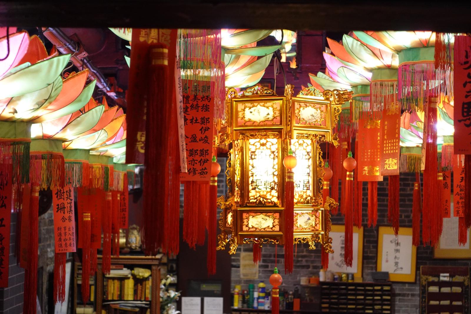 Vibrant, colorful lanterns embellished with blessings gracefully hang from the roof